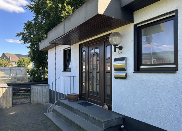 Blick auf den Hauseingang des Einfamilienhauses mit weißer Putzfassade in Schloß Holte